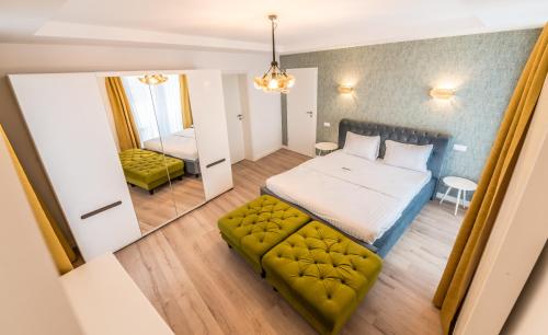 a bedroom with a bed and a couch and a mirror at UBA Accommodation Aparthotel in Cluj-Napoca