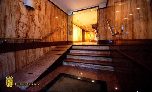 a hallway with stairs in a building with wooden walls at Rey Fernando in Santiago de Compostela