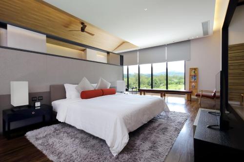 a bedroom with a large white bed with red pillows at Midori Clark Hotel and Casino in Clark