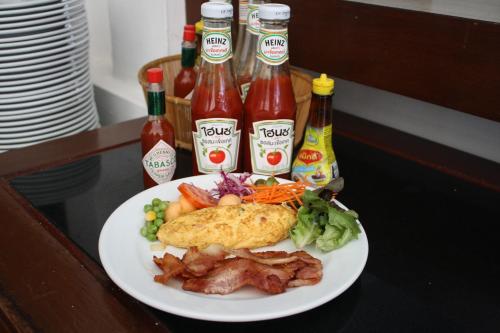 卡伦海滩Access Resort & Villas - SHA Plus的桌上放着一盘食物，配着番茄酱和芥末酱。