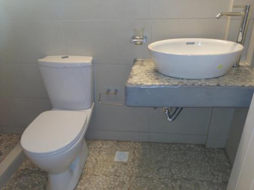a bathroom with a white toilet and a sink at Milos Bay Suites in Adamas