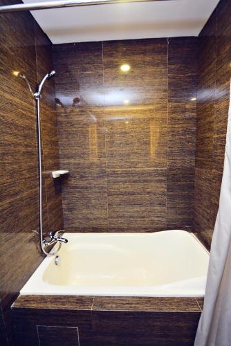 a bathroom with a bath tub and a shower at Citystate Asturias Hotel Palawan in Puerto Princesa City