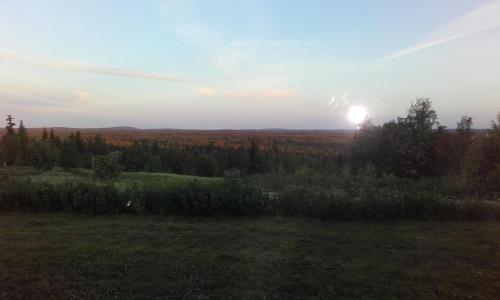 a view of a field with the sun in the sky at Holiday Home Byvägen 38 in Nattavaara