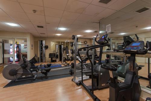 a gym with several treadmills and elliptical machines at The Grand Burstin Hotel in Folkestone