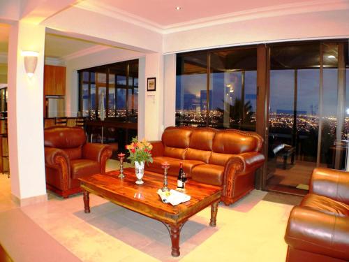 a living room with leather furniture and a table at Keret Accommodation in Bellville