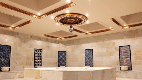 a lobby with a large marble table and a chandelier at Artemis Resort Wellness Hotel in Štúrovo