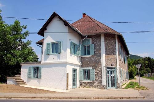 an old house with green shutters on a street at Vánkos in Badacsonyörs