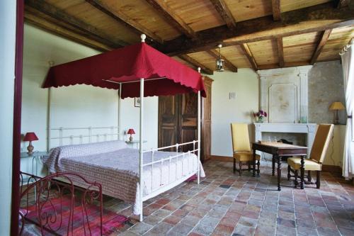 a bedroom with a bed with a red umbrella at Domaine les Galards in Le Garde