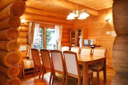 ein Esszimmer mit einem Tisch und Stühlen in einer Hütte in der Unterkunft Rental Log Urube Village in Tsumagoi