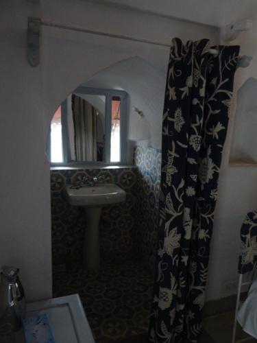a bathroom with a sink and a mirror at Labboo'z Café and Lodge in Maheshwar