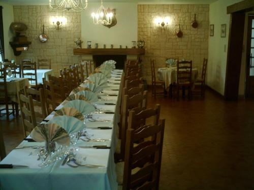 a long table in a room with tables and chairs at Hôtel L'Argonn' Auberge in Apremont