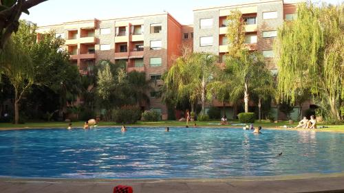 a group of people swimming in a swimming pool at Ritaj Apartement in Marrakesh