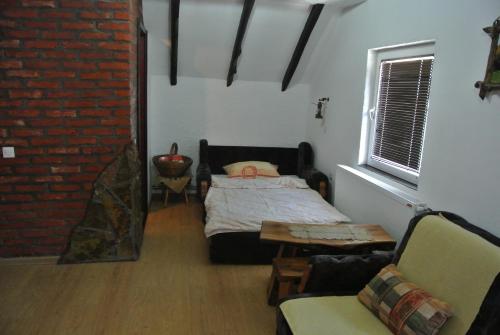 a bedroom with a bed and a brick wall at Apartmani Mali Raj Rudnik in Rudnik Kačerski