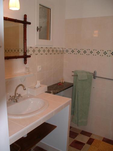 une salle de bain blanche avec un lavabo et un miroir dans l'établissement Domaine les Galards, à Le Garde