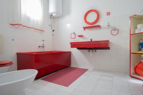 a bathroom with a red tub and a sink at Apartments PODATOK 4 in Primošten