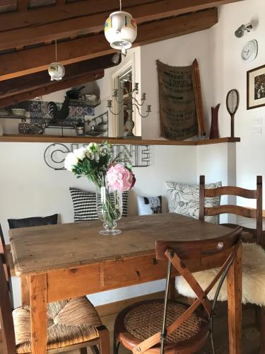 a dining room table with a vase of flowers on it at Locanda San Tomaso in Treviso