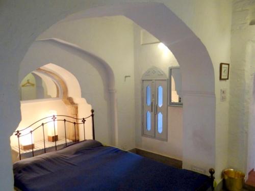 a bedroom with a bed and an arched doorway at Labboo'z Café and Lodge in Maheshwar