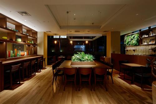 a restaurant with a table and chairs and a bar at HOTEL FORZA HAKATA-GUCHI in Fukuoka