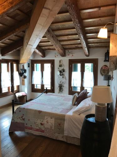una camera con un grande letto in una stanza con finestre di Locanda San Tomaso a Treviso