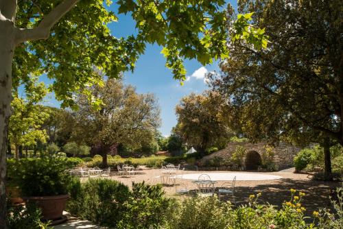 a garden with tables and chairs and trees at San Giovanni Terme Rapolano in Rapolano Terme