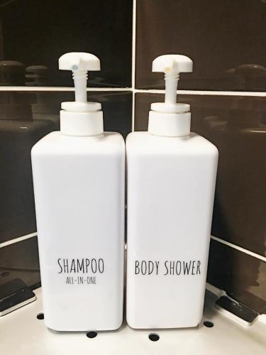 two bottles of shampoo and a body cleaner on a bathroom counter at KSTAR METRO Hotel in Seoul