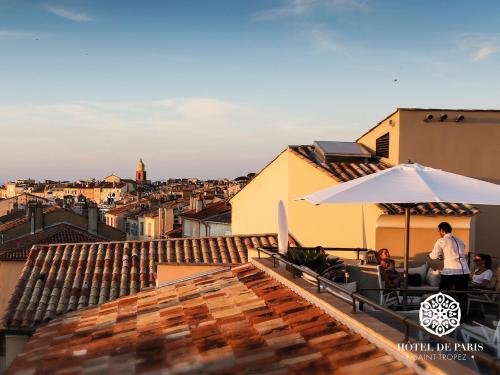 a balcony with an umbrella and a view of a city at Hôtel de Paris Saint-Tropez in Saint-Tropez