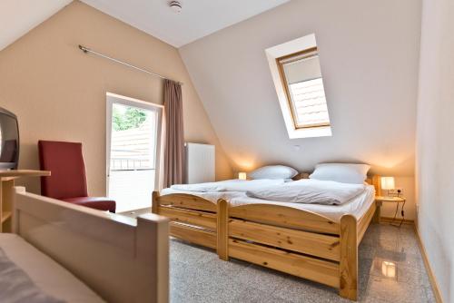 Schlafzimmer mit einem Bett und einem Fenster in der Unterkunft Pension Alte Feuerwehr in Schüttorf