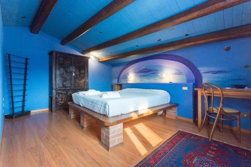 a bedroom with a bed and a blue wall at Agriturismo Podere Villa Alessi in Cinto Euganeo