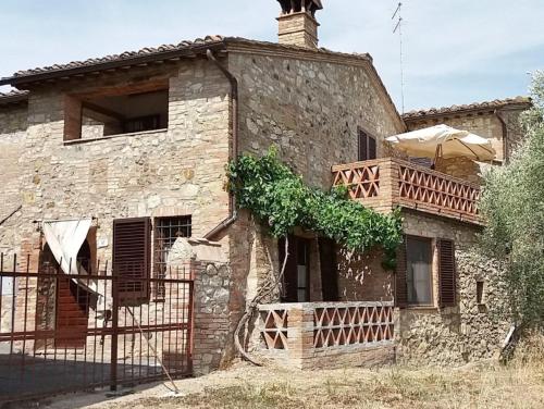 an old stone house with a wooden balcony at Casa dei Borghi in Murlo