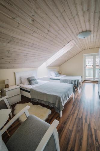two beds in a room with a wooden ceiling at Väike-Mere Villa in Haapsalu