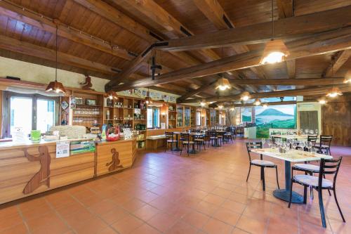 Cinto EuganeoにあるAgriturismo Podere Villa Alessiの木製の天井、テーブルと椅子のあるレストラン