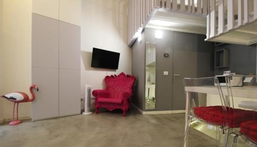 a living room with red chairs and a tv at Italianway-Eustachi in Milan