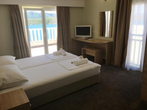 a hotel room with two beds and a television at Apartments Dalmatinka in Neum