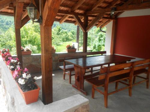 a patio with a wooden table and chairs and a table at Vikendica RTANJ in Rtanj