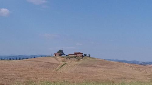 a field with houses on top of a hill at Casa dei Borghi in Murlo