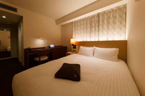 Habitación de hotel con cama con almohada en HOTEL FORZA HAKATA-GUCHI en Fukuoka