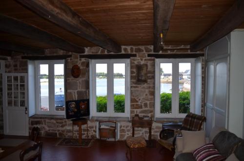 sala de estar con 3 ventanas y pared de piedra en Villa Aman An Ty, en Belz