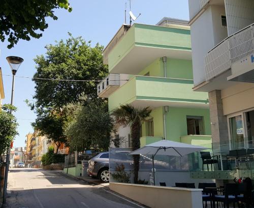 un edificio con un ombrello accanto a una strada di Residence Diffuso Arcobaleno a Gabicce Mare