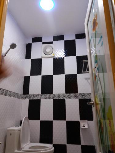 a bathroom with a black and white checkered wall at Heuan Na Khee in Udon Thani