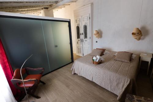 a bedroom with a bed with a glass wall at Monte Do Malhao - Art, Eco & Spa in Castro Marim