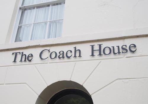 a sign for the coach house on a building at The Coach House in Canterbury