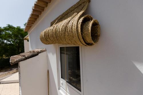 a basket on the side of a building with a window at Monte Do Malhao - Art, Eco & Spa in Castro Marim