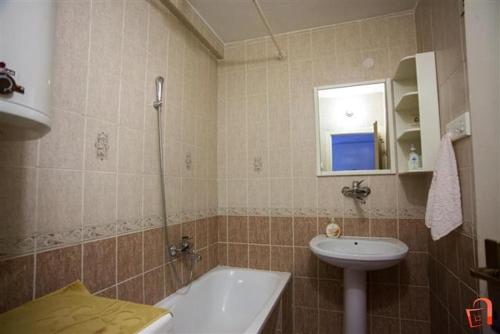 a bathroom with a sink and a tub and a toilet at Apartment Buzarovski in Skopje