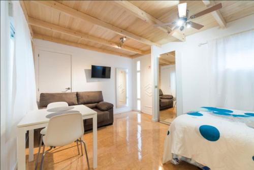 拉斯帕爾馬斯的住宿－Studio Las Palmas Central Rooms，一间卧室配有一张床、一张桌子和一张沙发