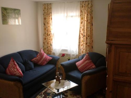 a living room with a blue couch and red pillows at Landgasthof zum Brückenwirt in Starnberg