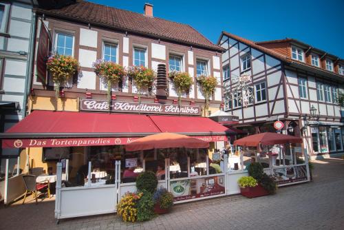 um edifício com um restaurante com guarda-sóis numa rua em Ferienapartments Schnibbe em Bad Lauterberg