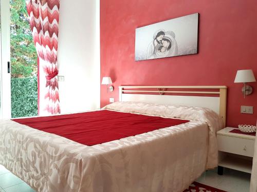 シャッカにあるVilla Rosellaの赤い壁のベッドルーム1室(大型ベッド1台付)