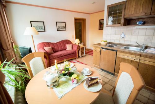 a kitchen and living room with a table with a cake at Ferienapartments Schnibbe in Bad Lauterberg