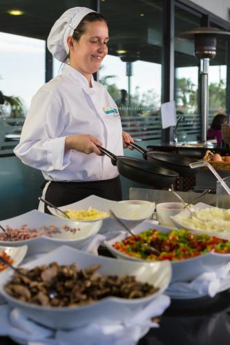 VidaMar Resort Hotel Madeira في فونشال: شيف واقف في مطبخ يحضر طعام