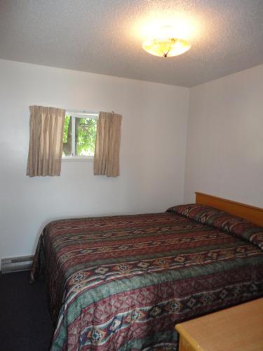 a hotel room with a bed and a window at Spanish Fiesta Resort in Osoyoos